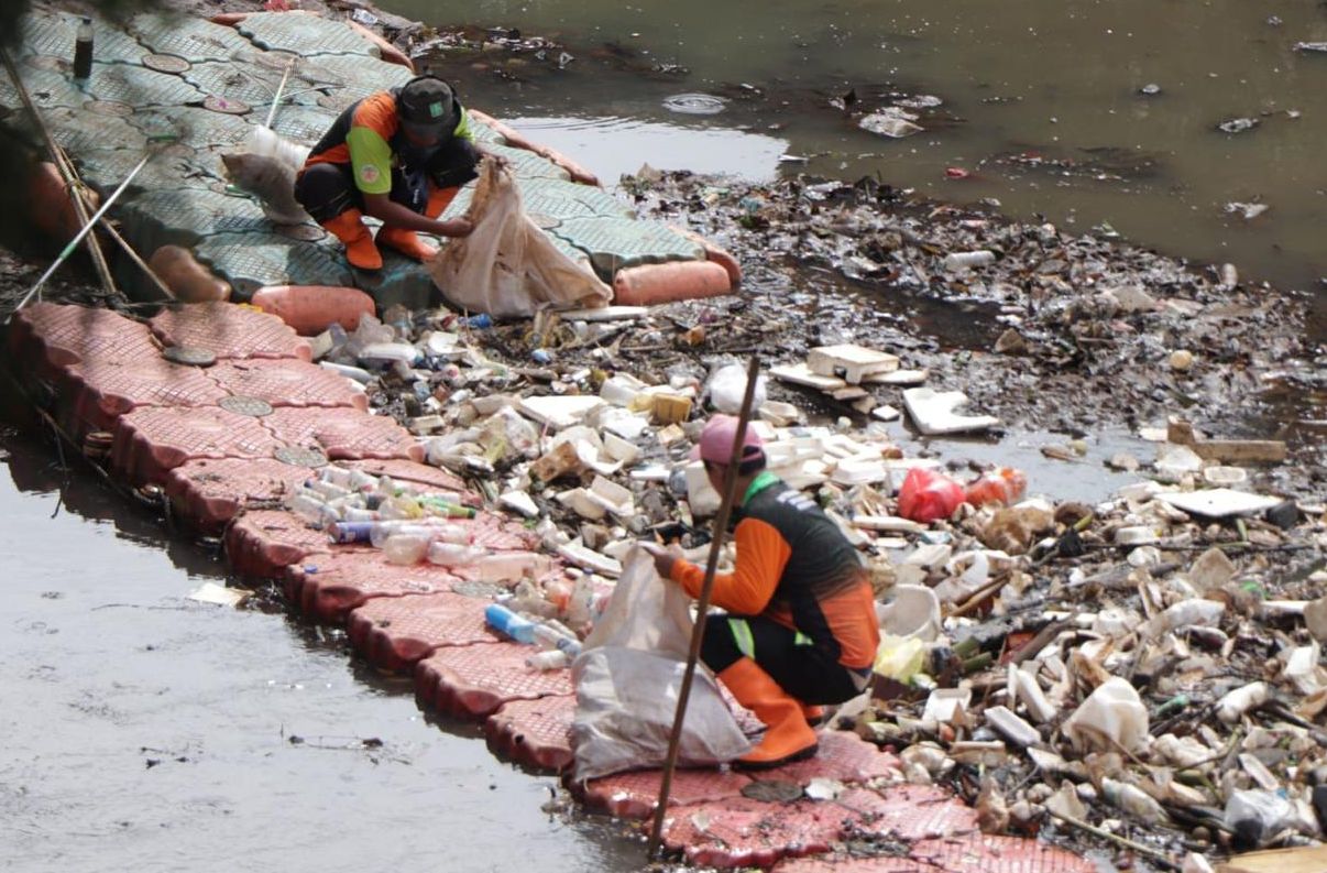 Petugas sedang membersihkan sampah <b>(Humas DKI)</b>