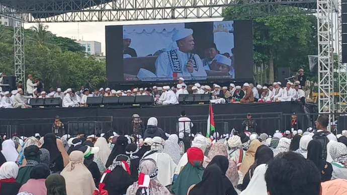 Massa yang hadir dalam reuni akbar Persaudaraan Alumni (PA) 212 mendengarkan pesan Imam Besar Habib Muhammad Rizieq Syihab di dalam kawasan Monumen Nasional (Monas), Senin (2/12/2024) pagi.